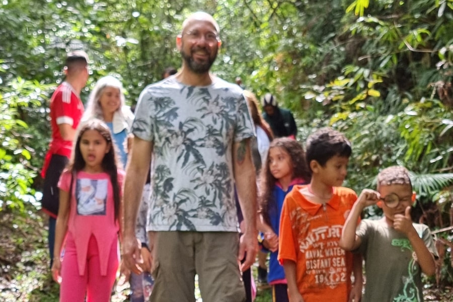 Foto de adultos e crianças andando na floresta