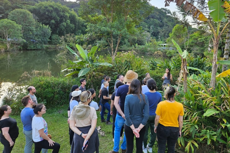 Foto de várias pessoas agrupadas, olhando plantas