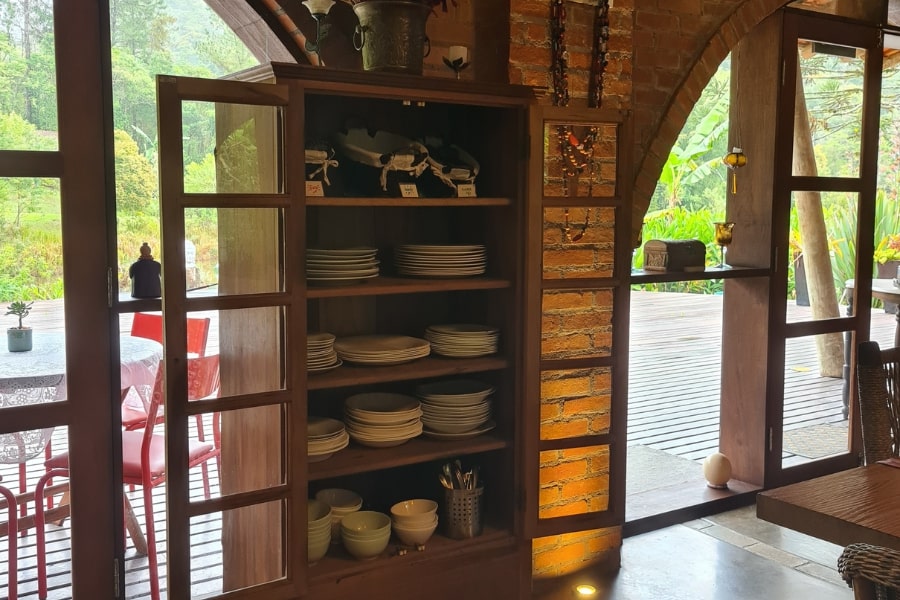 Foto de detalhe do restaurante, com armário de pratos aberto no canto da sala