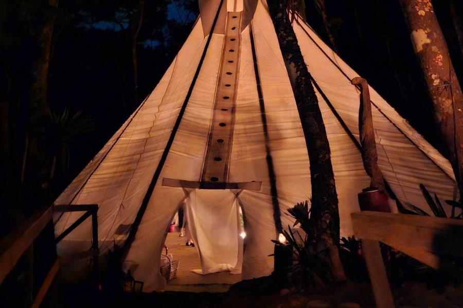 Foto de uma grande tenda bege e detalhada na noite