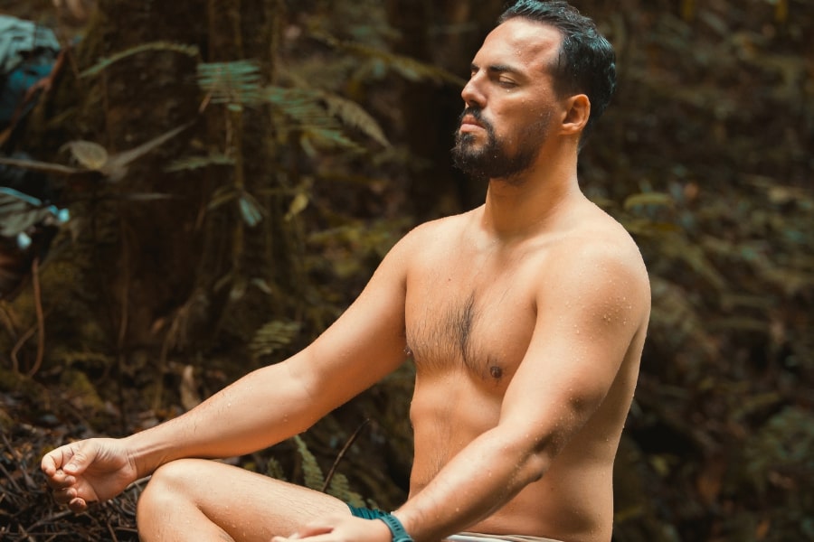 Foto de homem meditando na floresta