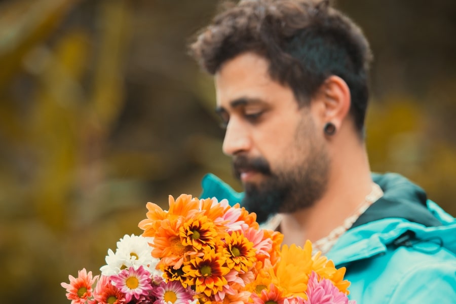 Foto de um homem com grande bouquet de flores coloridas