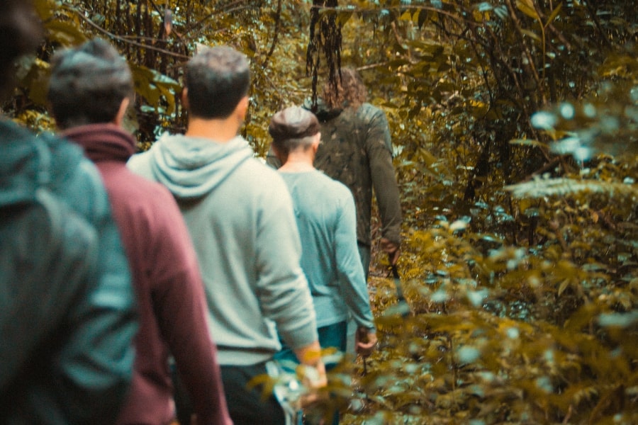 Foto de homens caminhando pelo mato