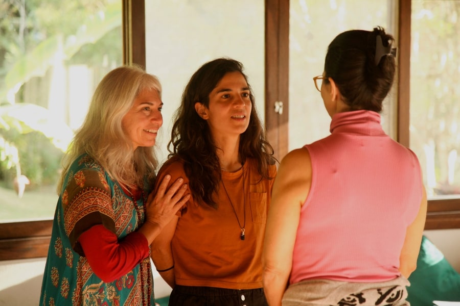 Foto de 3 mulheres em pé, conversando