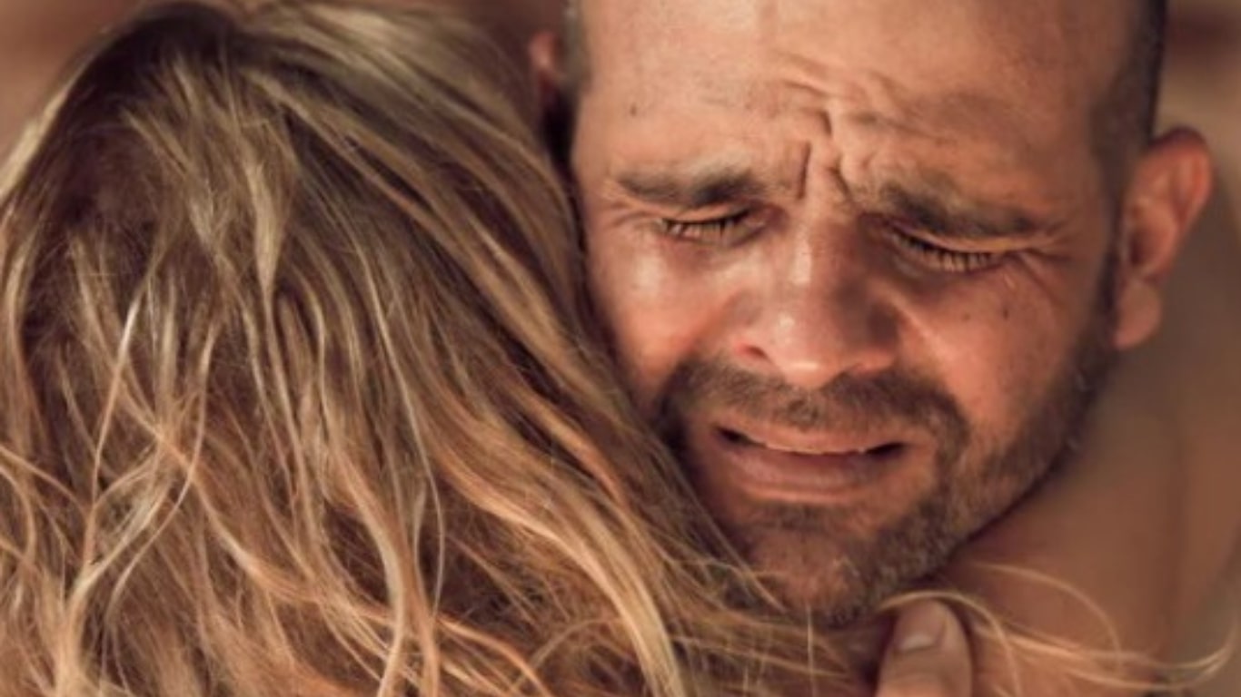Foto homem e mulher se abraçando e chorando
