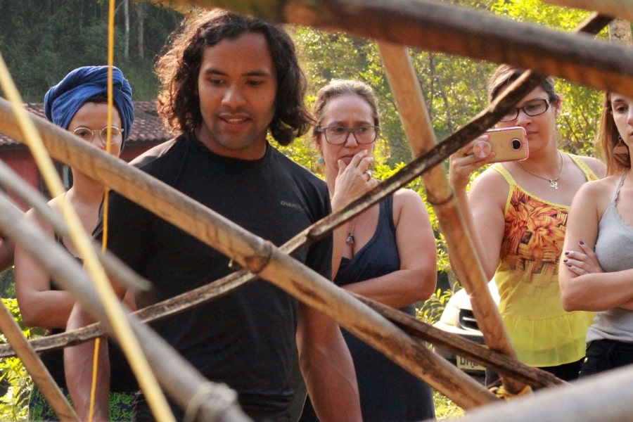 Foto de pessoas atrás de uma estrutura de madeira vazada