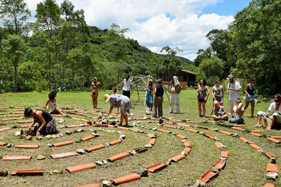 Foto de pessoas trabalhando num projeto como um labirinto, feito de telhas e plantas