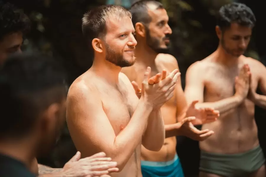 Foto de homens em pé, sem roupa, ouvindo explicações