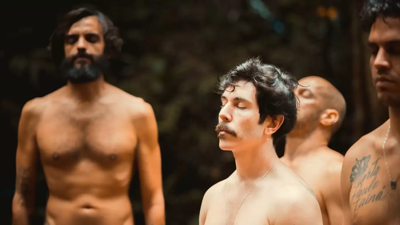 Foto de alguns homens de peito nu, e olhos fechados, em meditação