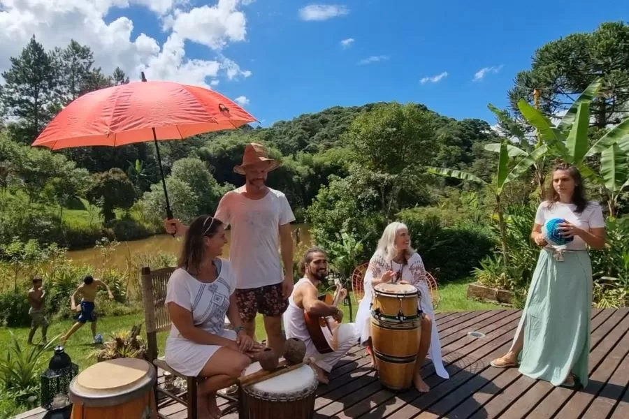 Grupo de pessoas tocando instrumentos no deck em um dia de sol.